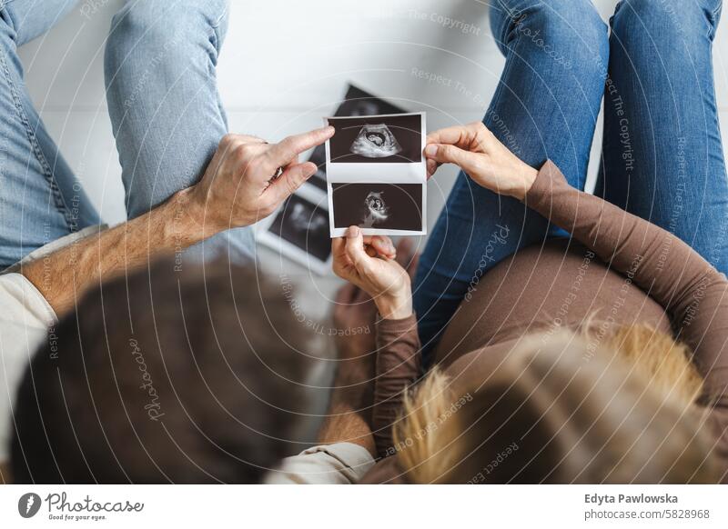 Paar, das ein Baby erwartet, sieht sich Ultraschalluntersuchung der Schwangerschaft an schwanger Erwachsener Vorfreude wartend Bauch Geburt Körper Pflege