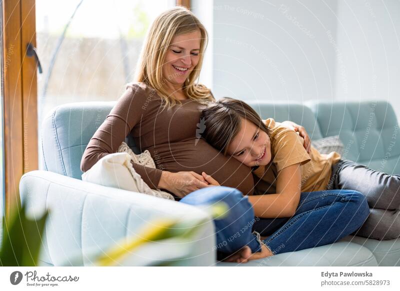 Kleiner Junge mit seiner schwangeren Mutter zu Hause Schwangerschaft Erwachsener Vorfreude wartend Baby Bauch Geburt Körper Pflege Kaukasier Kind erwartungsvoll