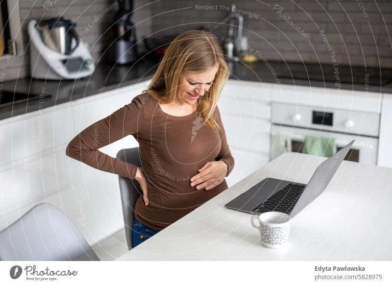 Schwangere Frau arbeitet zu Hause mit Laptop Schwangerschaft schwanger Erwachsener Vorfreude wartend Baby Bauch Geburt Körper Pflege Kaukasier Kind