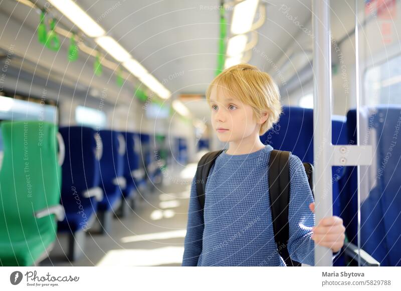 Niedlicher Junge in einer Kabine der U-Bahn oder eines Nahverkehrszugs. Kind Passagier der komfortablen Transport der großen Stadt. Städtische Infrastruktur.