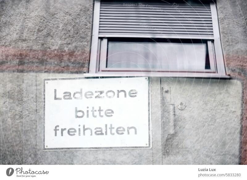 Ladezone bitte freihalten - Schild fotografiert durch die Fensterscheibe eines davor parkenden Autos Zahn der Zeit Sicherheit Ordnung Halteverbot Verkehrswege