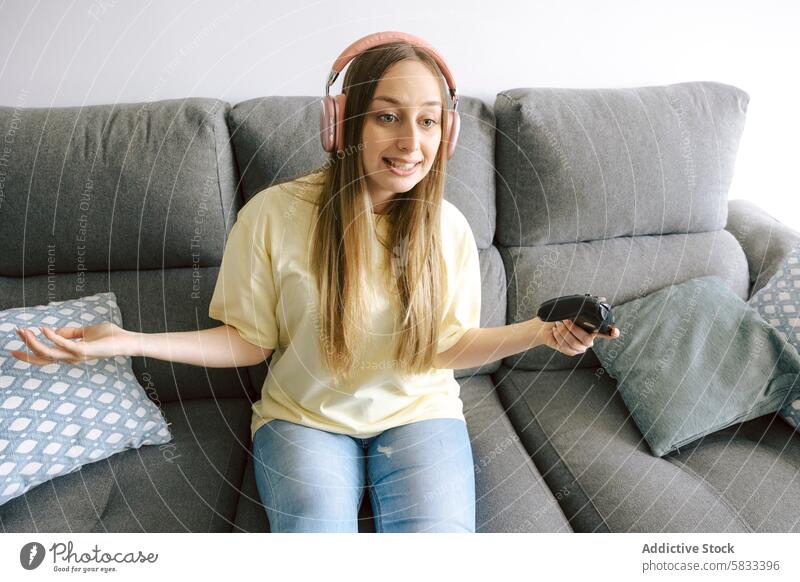 Frau genießt Videospiele auf einem gemütlichen Sofa Spielen heimwärts Freizeit Entertainment Headset Kopfhörer Liege bequem Sitzen Genuss Spaß spielen Regler