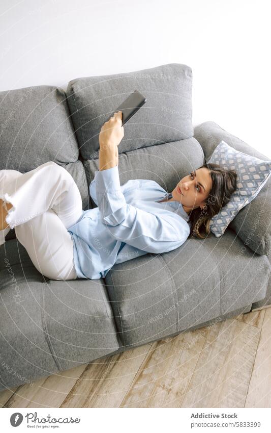 Frau entspannt auf dem Sofa mit einem Tablet entspannend Tablette heimwärts Freizeit Komfort lässig Selfie im Innenbereich Technik & Technologie Lifestyle