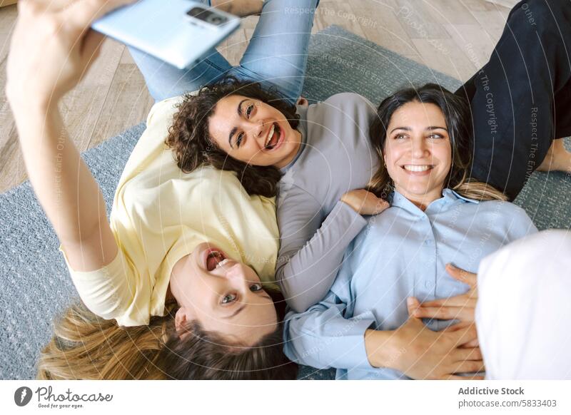 Freunde machen ein Selfie beim Entspannen zu Hause Freundschaft heimwärts Frauen liegend Stock Fröhlichkeit lässig Freude Lächeln Fotokamera Smartphone Bonden