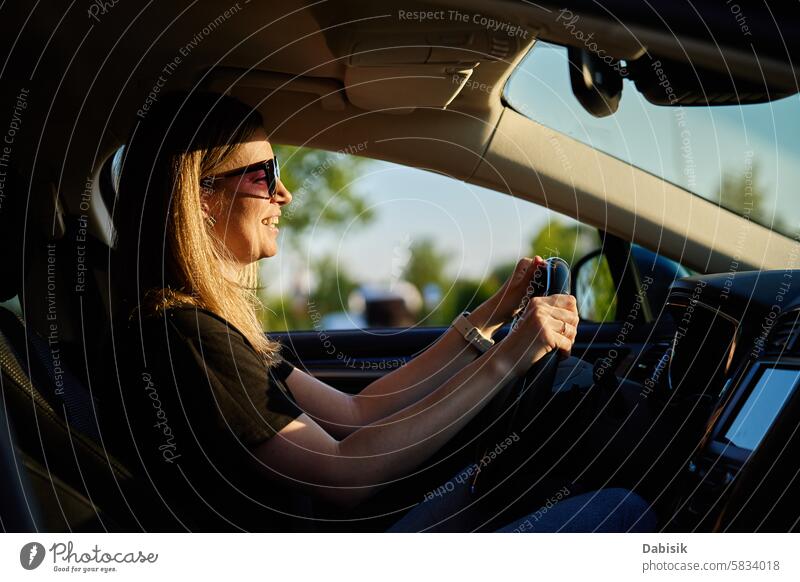 Eine glückliche Frau sitzt im Auto. Blick durch die Windschutzscheibe PKW Fahrer genießen Glück fahren Fahrzeug achtsam reisen Erwachsener attraktiv schön
