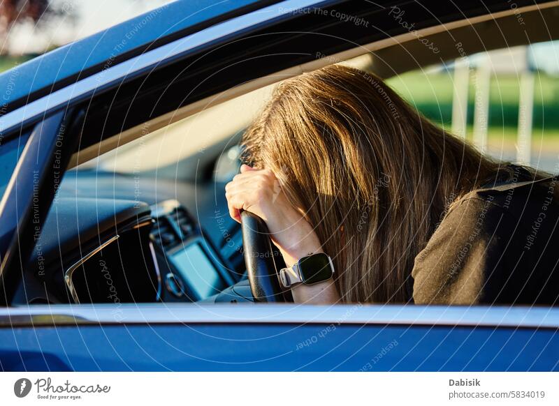 Frau sitzt im Auto und stützt ihren Kopf auf das Lenkrad PKW Depression fahren emotional gelangweilt Fahrer Traurigkeit psychische Gesundheit Problematik