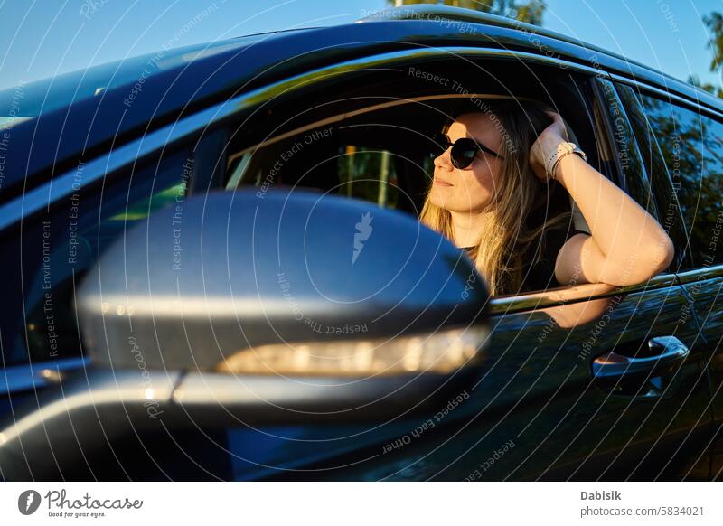 Frau mit Sonnenbrille fährt Auto fahren PKW Fahrer sonnig Lenkrad Fahrzeug Lächeln Tageslicht Autoreise ländlich Sonnenlicht Porträt Windschutzscheibe Ausflug