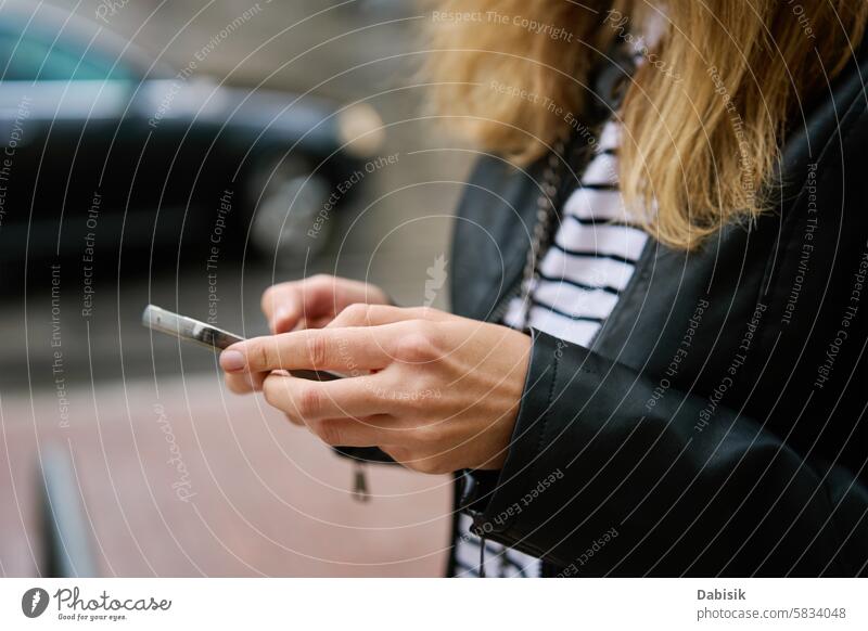 Frau benutzt Smartphone auf einer Straße in der Stadt Großstadt Mitteilung online benutzend im Freien Browsen Hand Beteiligung Gerät soziale Netzwerke laufen