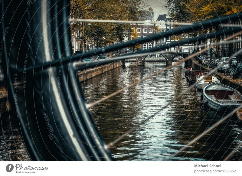 Blick durch ein Fahrradrad: Gracht in Amsterdam Niederlande Farbfoto Tourismus Ferien & Urlaub & Reisen Boot Boote Wasser Kanal friedlich friedliche Stimmung