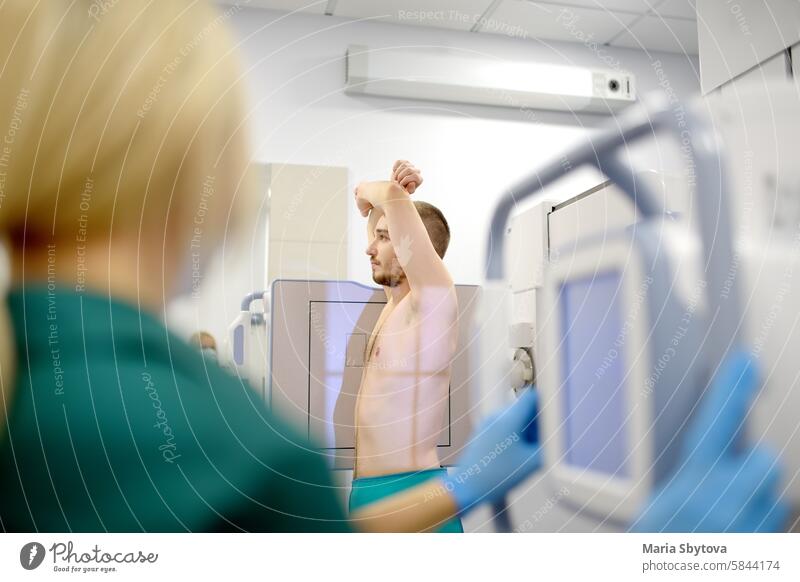 Eine Radiologin macht eine Röntgenaufnahme der Lunge eines Patienten im Röntgenraum einer modernen Klinik. Der Arzt führt eine Fluorographie durch. Die medizinische Untersuchung der Menschen dient der Vorbeugung der Tuberkuloseverbreitung