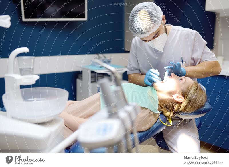 Zahnarzt und Patient in einem modernen medizinischen Zentrum. Der Arzt behandelt die Zähne einer jungen Frau im Krankenhaus. Der Arzt untersucht den Patienten vor einer kieferorthopädischen oder prothetischen Behandlung.