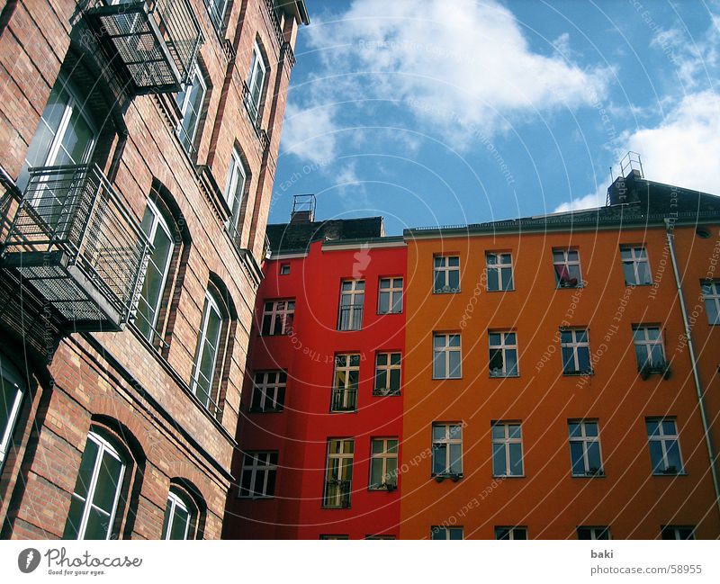 Hinterhof in Berlin Haus gelb Wolken orange blau Farbe Himmel Freude Freiheit außenaufname