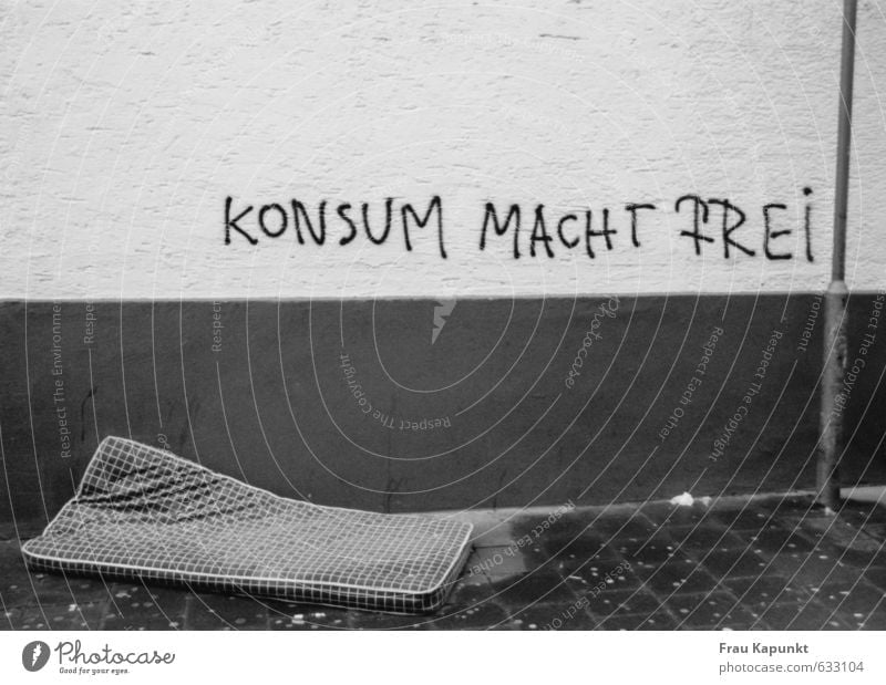 Konsum macht frei. Mauer Wand Laternenpfahl Bürgersteig Schlafmatratze Graffiti nass Zukunftsangst Ungerechtigkeit Menschenleer Armut Freiheit