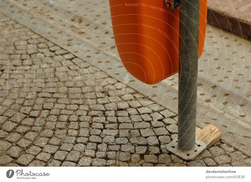 Stadtmöbel grau Müllbehälter Papierkorb Kopfsteinpflaster alt dreckig orange holzkeil Pfosten