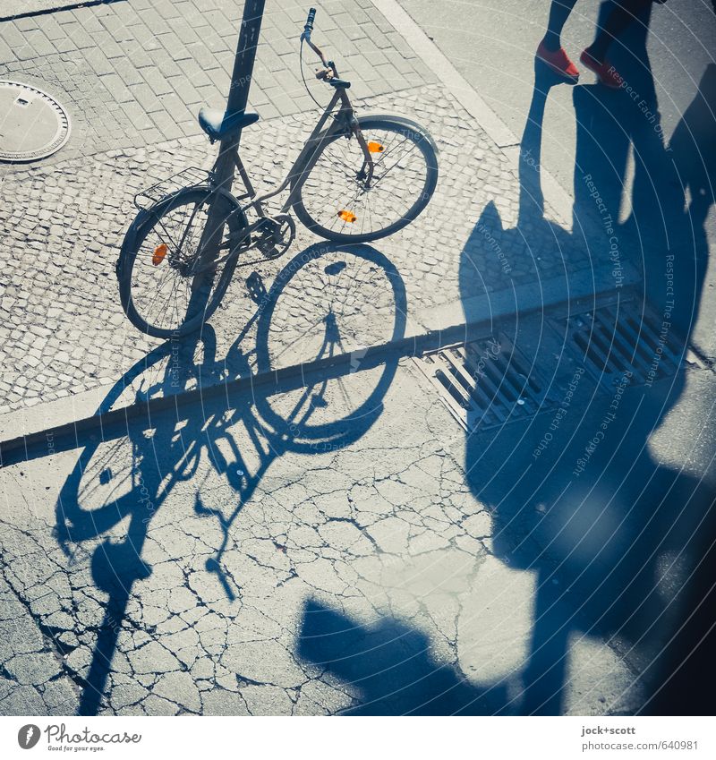 tritt ins Licht mit Schattenspiel Fuß Kreuzberg Fußgänger Straßenkreuzung Bürgersteig Gully Fahrrad Reflektor Riss gehen Irritation parken angeschlossen