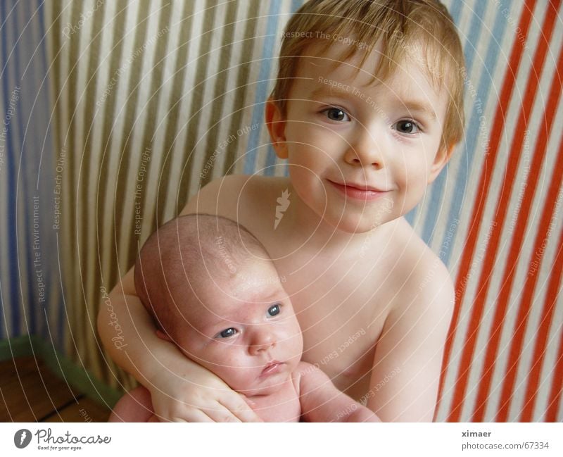 Liebevolle Umarmung Baby Kleinkind Kind Mädchen Schwester Bruder Umarmen nackt Streifen Holzfußboden Geborgenheit Geschwister Junge lachen Decke Auge Freude