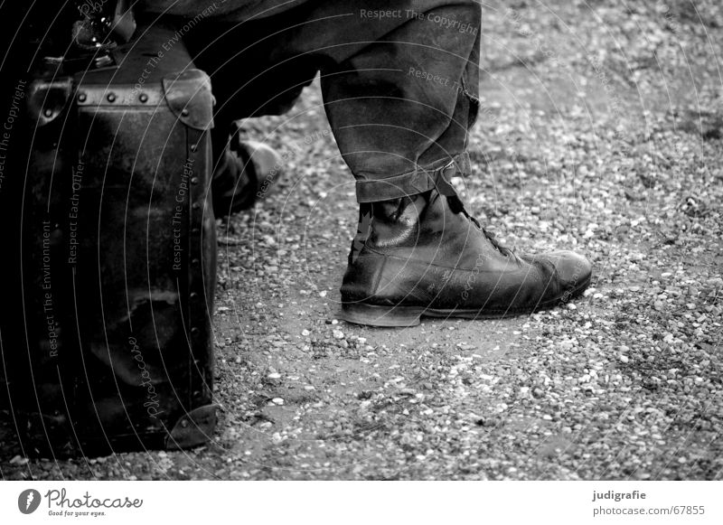 Warten Mann ruhig Koffer Hose Schuhe Kieselsteine schwarz weiß Ausdauer lang Zeit warten sitzen Sitzgelegenheit Erholung alt Theaterschauspiel geduldig Ungeduld