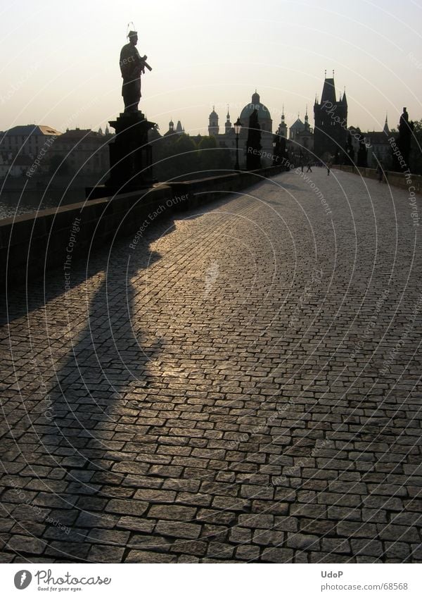 Einsamer Nepomuk Karlsbrücke Prag Tschechien Dämmerung Sonnenaufgang Denkmal Stadt Gegenlicht Morgen Turm Spitze Schatten Kontrast Brücke Silhouette nepomuk