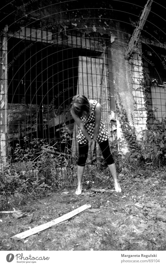 Vor den Trümmern Gitter Ruine Frau bücken Kleid Beine Schwarzweißfoto