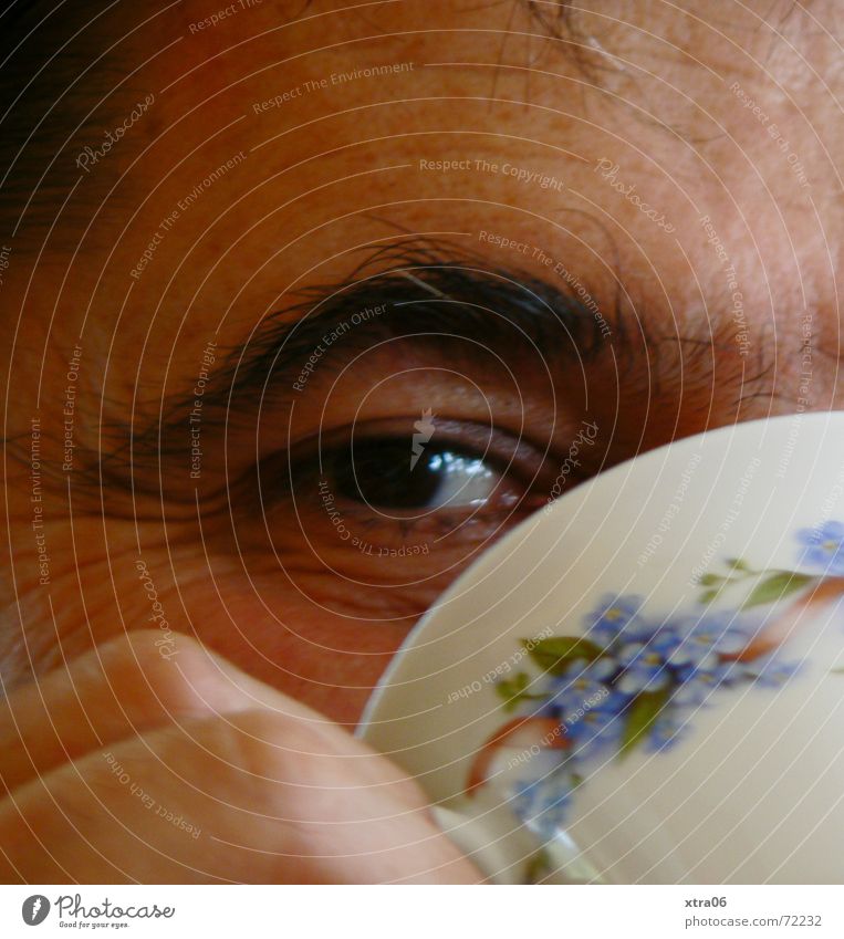 sieh mir ins Auge Augenbraue Mann Tasse Teetasse lügen aufreizend Lachfalte Finger Innenaufnahme trinken Kaffeetasse Blumenmuster Hand Mensch frech
