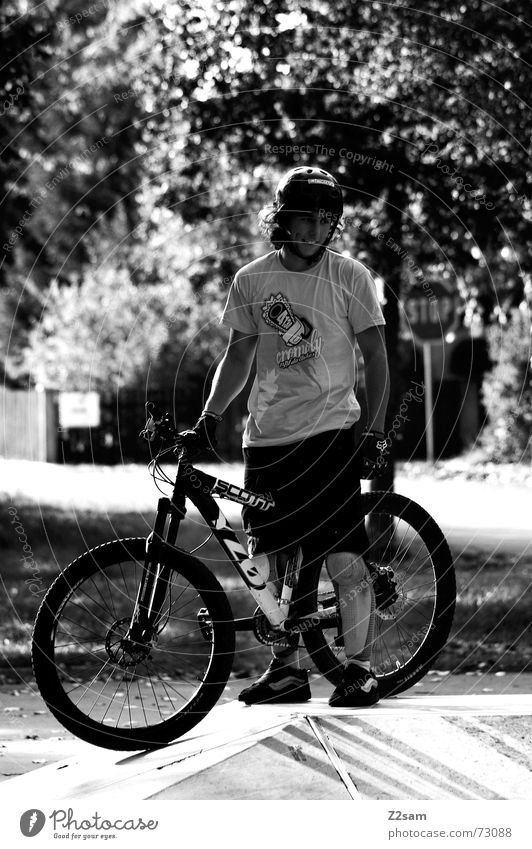 stop biking stehen Stil stoppen Park Helm lässig Fahrrad warten lachen Schilder & Markierungen Sonne Schwarzweißfoto scharz/weiss Funsport Coolness
