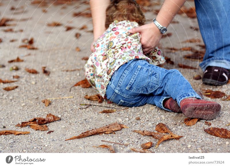 hingeplumst Farbfoto Außenaufnahme Tag Ganzkörperaufnahme Rückansicht Kind Beine Fuß Hose Schuhe Locken fallen heben Bodenbelag