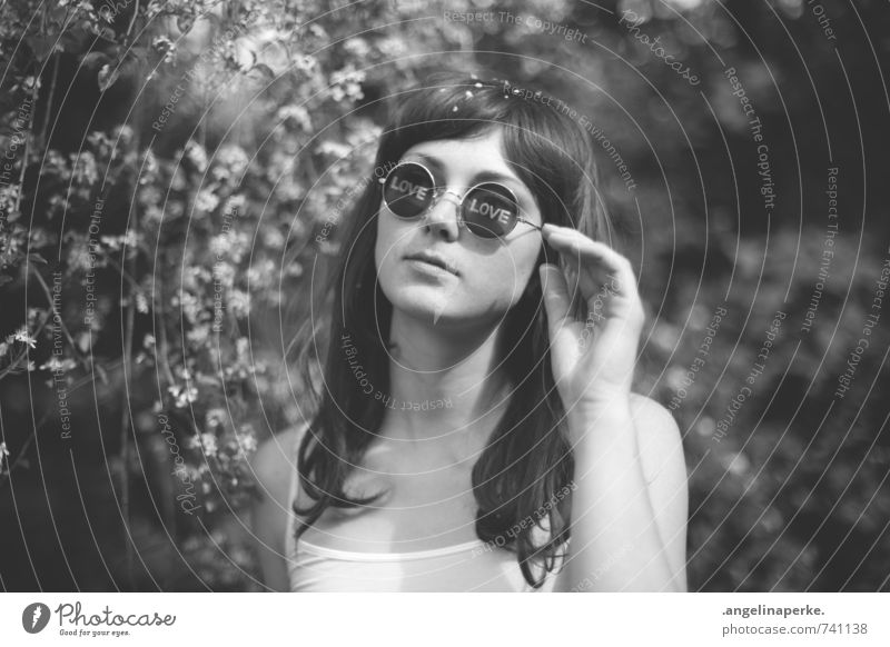 Frau steht unter einem Baum mit weißen Blüten, auf den Gläsern ihrer Sonnenbrille kann man die Worte "Love" lesen feminin Jugendliche Mensch Jugendkultur Natur