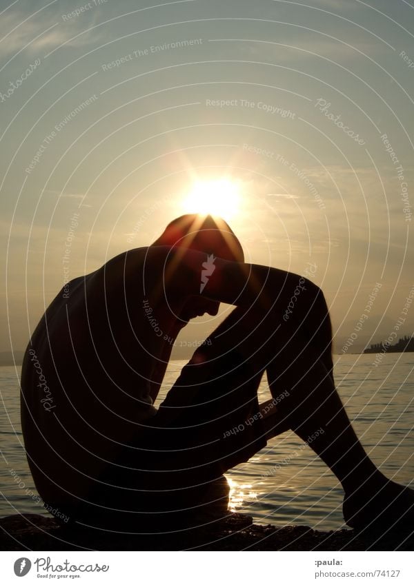 lesender Mann im Gegenlicht am Seeufer Sonnenuntergang Gardasee Buch Abenddämmerung Sommer Italien Silhouette Wasser corona Lektüre Außenaufnahme