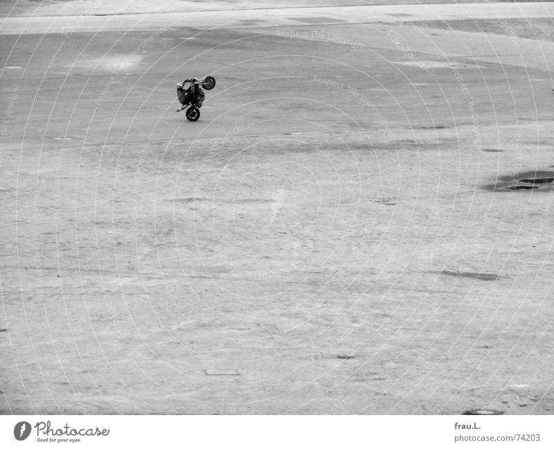 einsames Training Rad Mut üben Motorradfahrer Mann Platz Einsamkeit fahren Sport Spielen Verkehr Mensch kunststück kein beifall keiner sieht zu Künstler