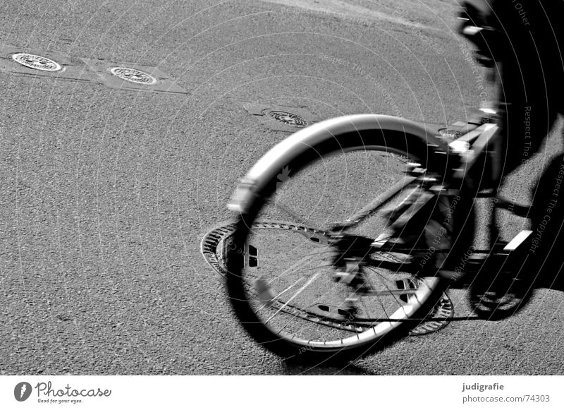 Kanaldeckel - Überrollzustand 1 Asphalt Fahrrad fahren Bewegung Schwung Gully Schacht unterirdisch Gußeisen schwarz weiß Straße Rolle überrollen Dynamik