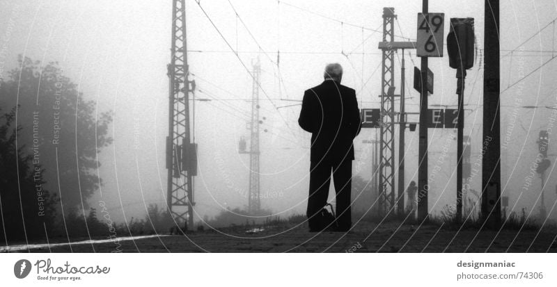 Warten am Bahnhof Bensheim grau Nebel kalt schwarz dunkel weiß Eisenbahn Bahnsteig Mann stehen lesen Anzug Morgen spät Zeit trist Gleise Trauer Verspätung