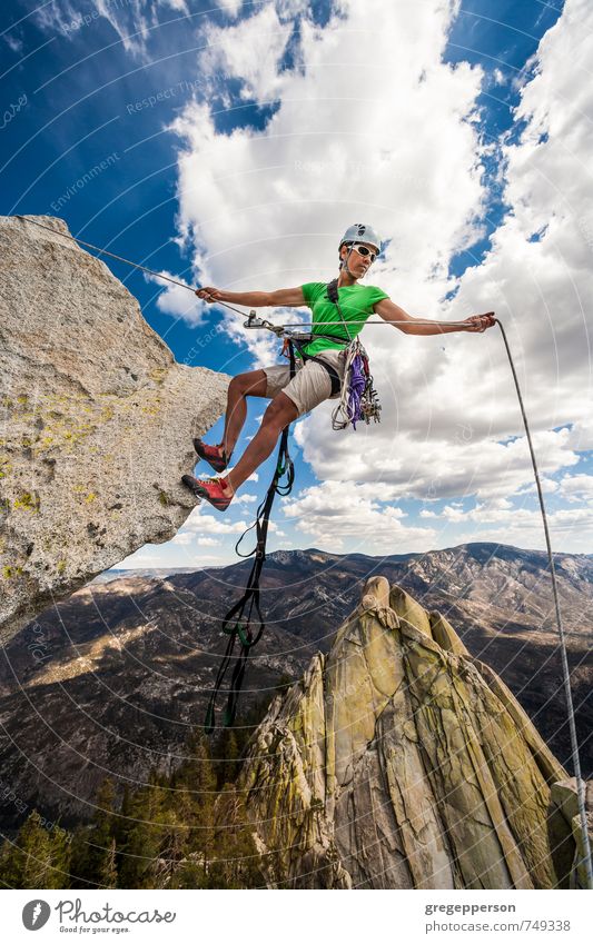 Der Kletterer seilt sich über die Kante ab. Leben Abenteuer Klettern Bergsteigen Erfolg 1 Mensch 30-45 Jahre Erwachsene Wolken Helm selbstbewußt Mut Tatkraft