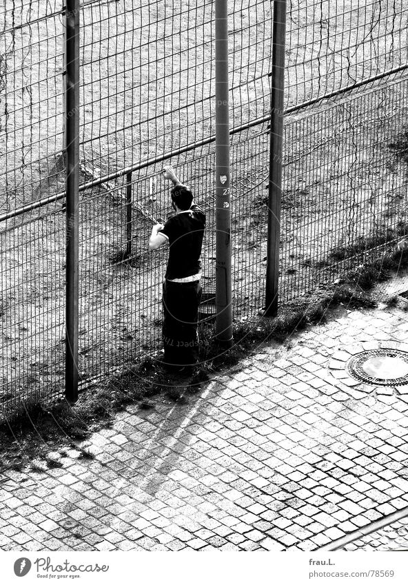 Zaungast Einsamkeit Maschendraht beobachten Blick Mann Fußballplatz Bart festhalten Straßenbelag Asphalt Hand Mensch Junger Mann Außenseiter gefangen aussperren