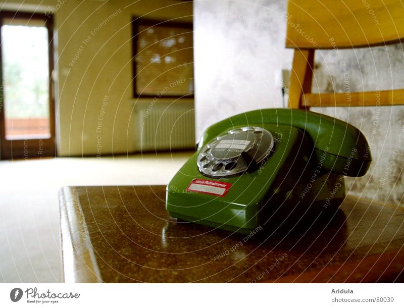 Altes grünes Telefon im leeren Wohnzimmer Drehscheibe Fenster Holz Trauer Rollo Einsamkeit Verständigung abgelegen Kommunikationsmittel unbenutzt Telefonhörer