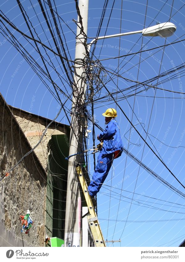 Kabelsalat Monteur Suva unsicher Helm gelb Arbeitsanzug durcheinander Elektrizität Bolivien chaotisch Strommast Laterne Südamerika Arbeiter Verzweiflung