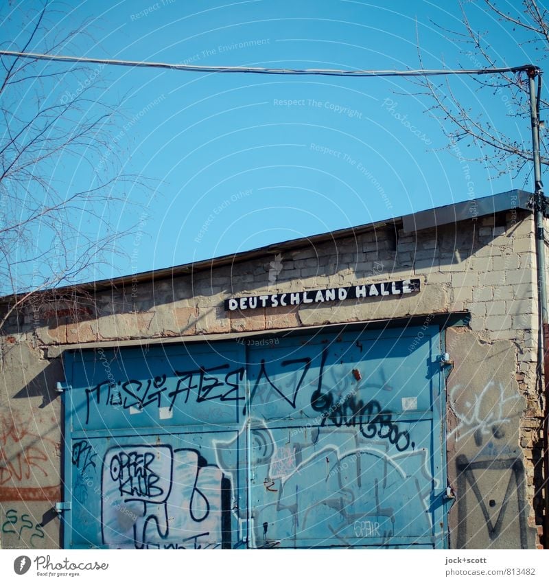 Deutschland Halle an einem ramponierten Schuppen Lagerhalle Tor Metalltür Flachdach Graffiti Wortspiel klein lustig trist blau bescheiden Verfall Ironie