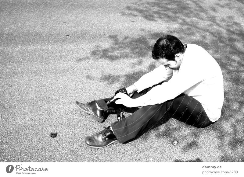 Der Fotograf Mann schwarz weiß Zapfen Stativ zdenek Mensch Schwarzweißfoto sitzen Bodenbelag Fotokamera Sonne Schönes Wetter