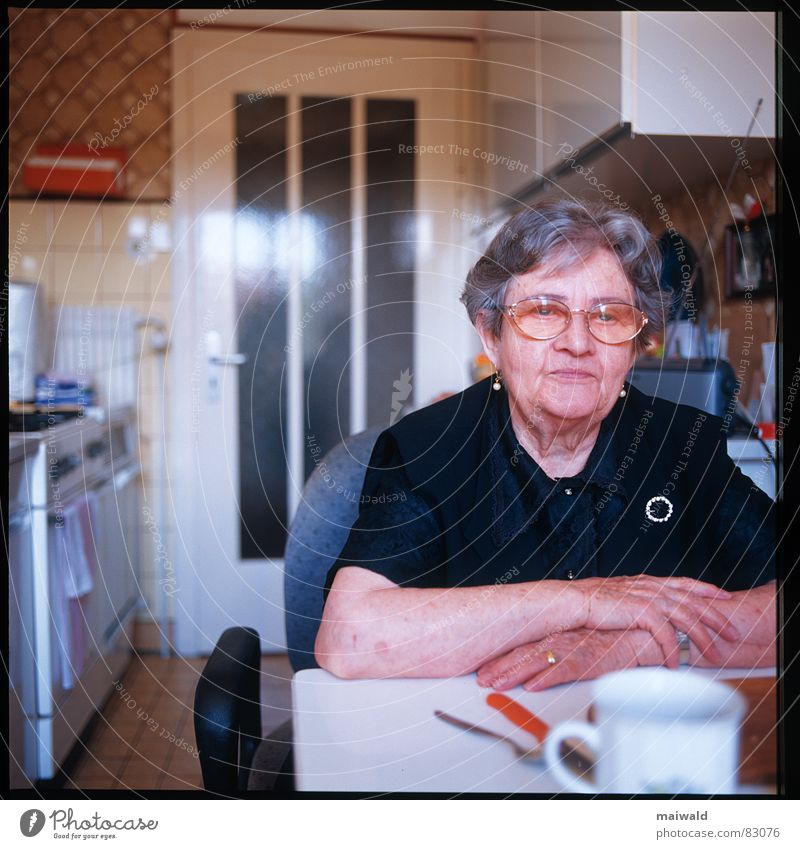 Witwe Großmutter Frau Einsamkeit Trauer Küche Vesper Denken grauhaarig Tisch Tasse Tiefenschärfe Brille Langeweile Hand Senior Becher Innenaufnahme Porträt alt