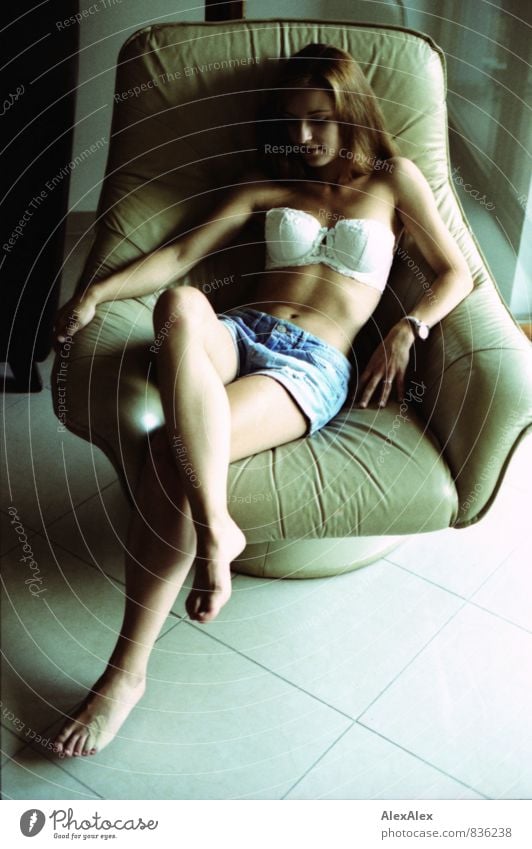 entspanntes Portrait mit Pflaster Junge Frau Jugendliche Körper 18-30 Jahre Erwachsene Raum BH Hotpants Barfuß brünett langhaarig Sessel sitzen träumen