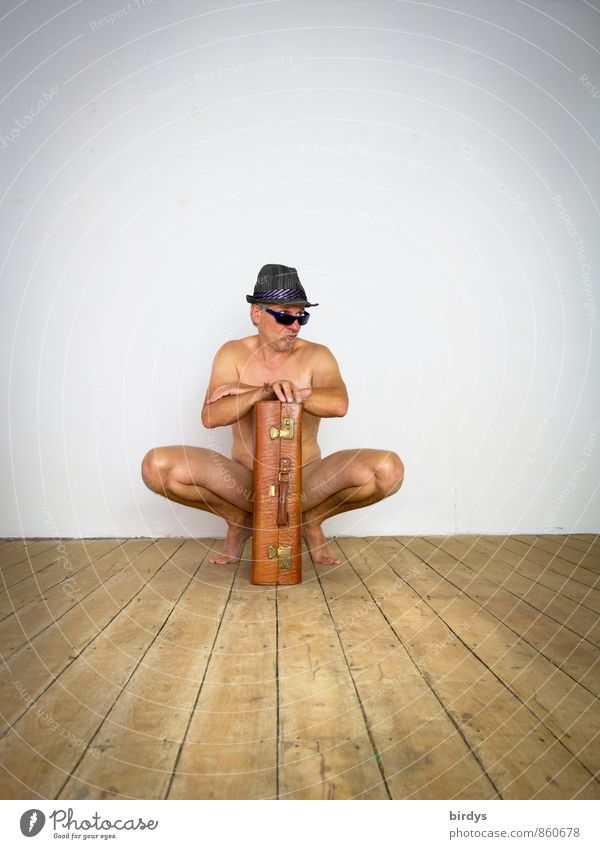 Nackter Mann mit Sonnenbrille, Hut und einem alten Koffer in lustiger Pose Erwachsene 1 Mensch 45-60 Jahre Holzfußboden beobachten hocken Blick ästhetisch