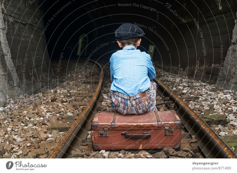 Kind in Vintage-Kleidung sitzt auf der Eisenbahnstrecke. Ferien & Urlaub & Reisen Ausflug Mensch Mädchen Junge Kindheit Natur Verkehr Koffer fallen sitzen