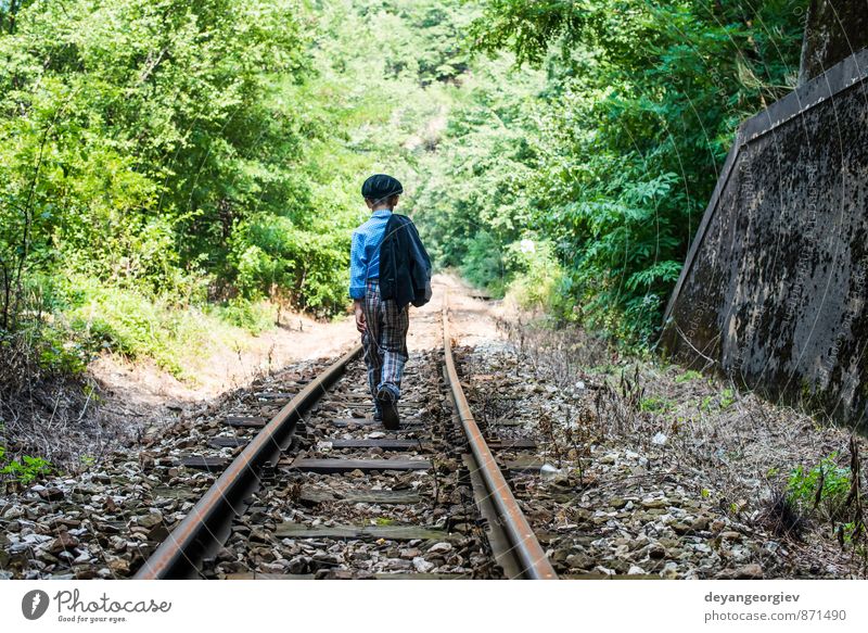 Kind geht auf der Eisenbahn spazieren Ferien & Urlaub & Reisen Mensch Junge Kindheit Natur klein niedlich Einsamkeit Menschen weg laufen Spaziergang Bahn jung