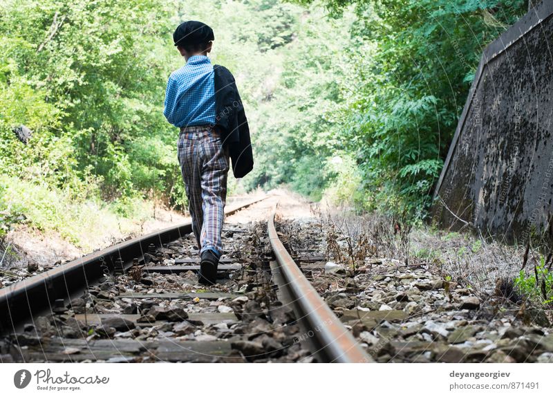 Kind geht auf der Eisenbahn spazieren Ferien & Urlaub & Reisen Mensch Junge Kindheit Natur klein niedlich Einsamkeit Menschen weg laufen Spaziergang Bahn jung