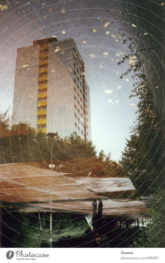 Liquid Plattenbau Gebäude Hochhaus Pfütze Mann Australien trüb Stadt Osten Reflexion & Spiegelung Friedrichshain Berlin Regen bedecken nachdenklich