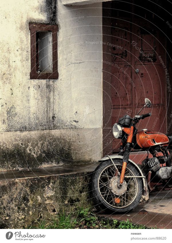 abgestellt Motorrad alt Haus Gebäude Fenster dunkel Stahl Putz dreckig grün weiß kalt Pause innehalten parken fahren Motorsport Verkehr Vergänglichkeit orange