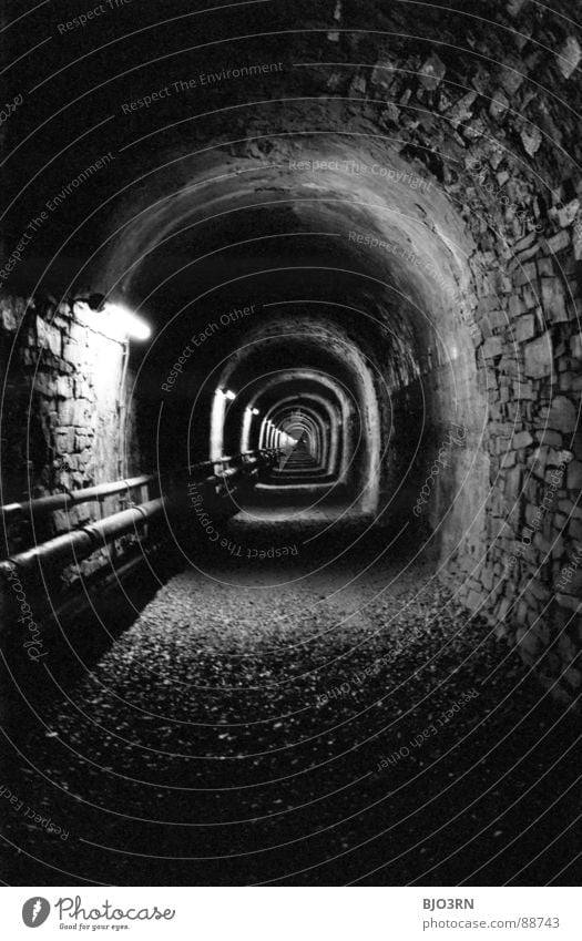 Wer geht vor? schwarz weiß Untergrund 2. Weltkrieg Schacht Tunnel London Underground Kanalisation analog Licht dunkel eng Fluchtpunkt Wand Kies Hochformat