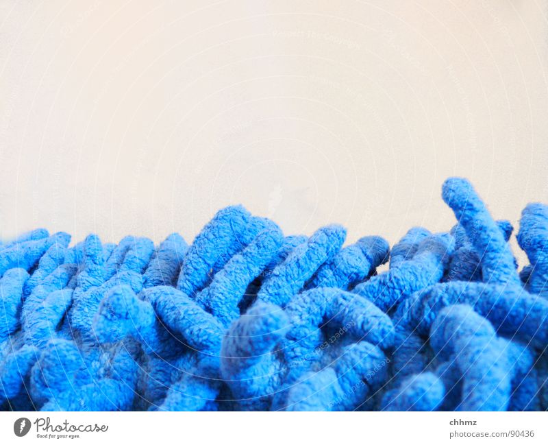Würstchen Teppich Fußmatte Stoff Textilien Faser blau Makroaufnahme Vor hellem Hintergrund Textfreiraum oben Badematte