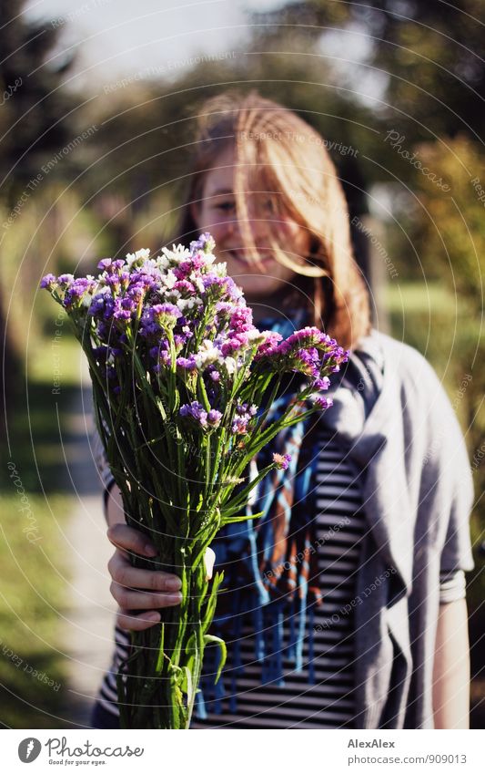 Glückwunsch! Freude Junge Frau Jugendliche 30-45 Jahre Erwachsene Wege & Pfade Schrebergarten Streifen blond langhaarig Blumenstrauß Strohblume geben hochhalten