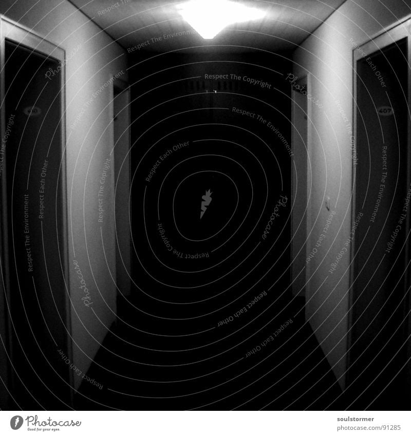 Das Licht in der Mitte des Tunnels... schwarz weiß Flur Lampe dunkel ungewiss Schalter Ende links rechts Raum Angst Panik Schwarzweißfoto Tür leer Bodenbelag