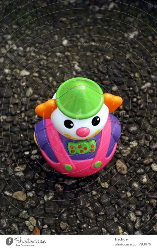 Straßenclown Spielzeug klein Einsamkeit ausgesetzt Asphalt mehrfarbig Vogelperspektive obskur Clown Statue plastikspielzeug Kontrast toy toys street Kindheit
